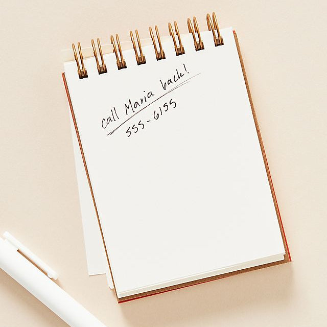 Notebook with a pen on a beige background