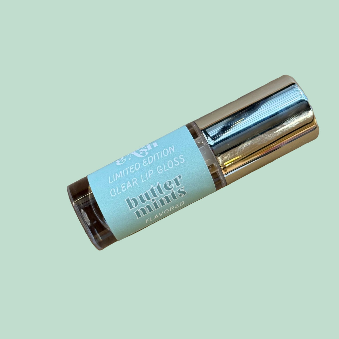 Butter Mints lip gloss on a mint green background