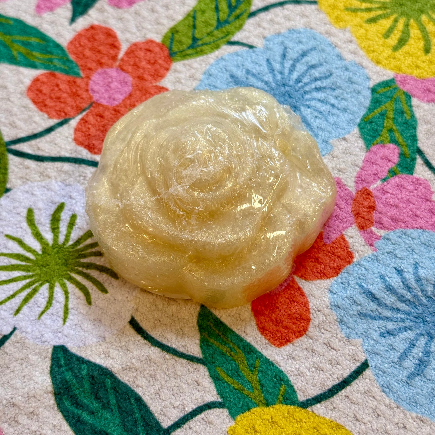 Rose-shaped bar of soap on a floral-patterned surface