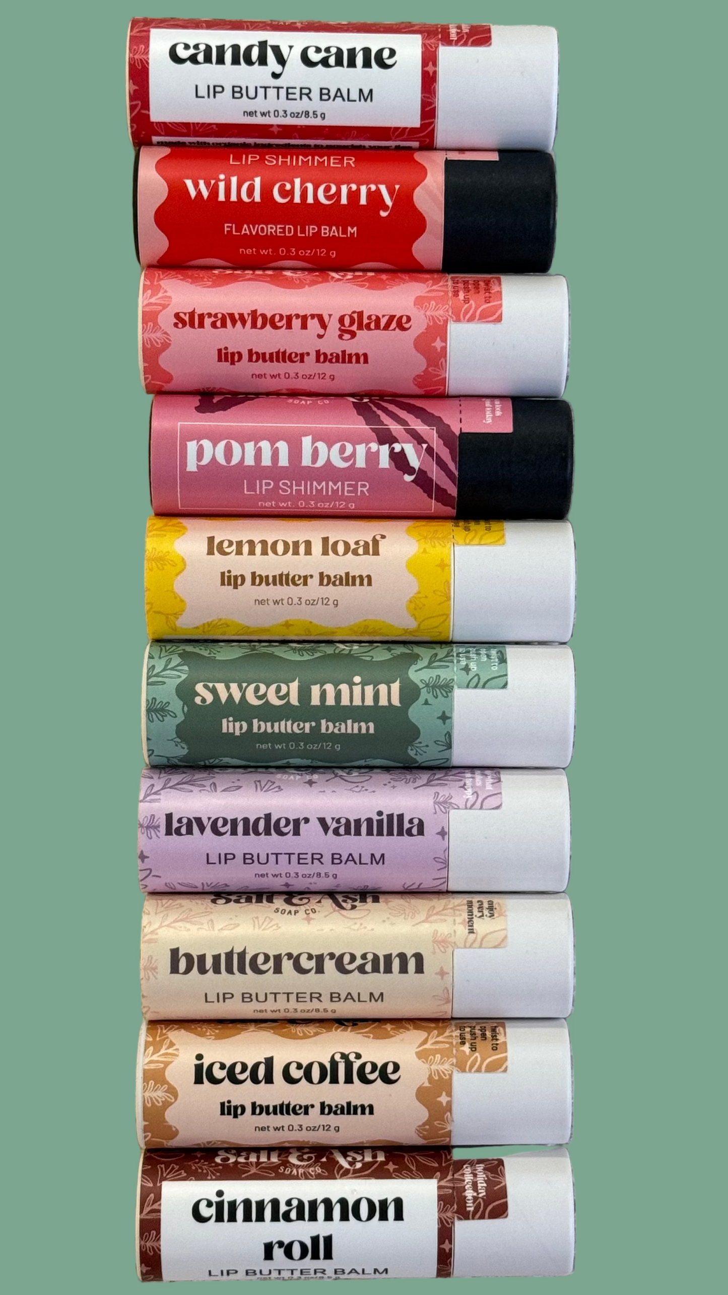 Row of lip balm tubes with various flavors on a textured surface