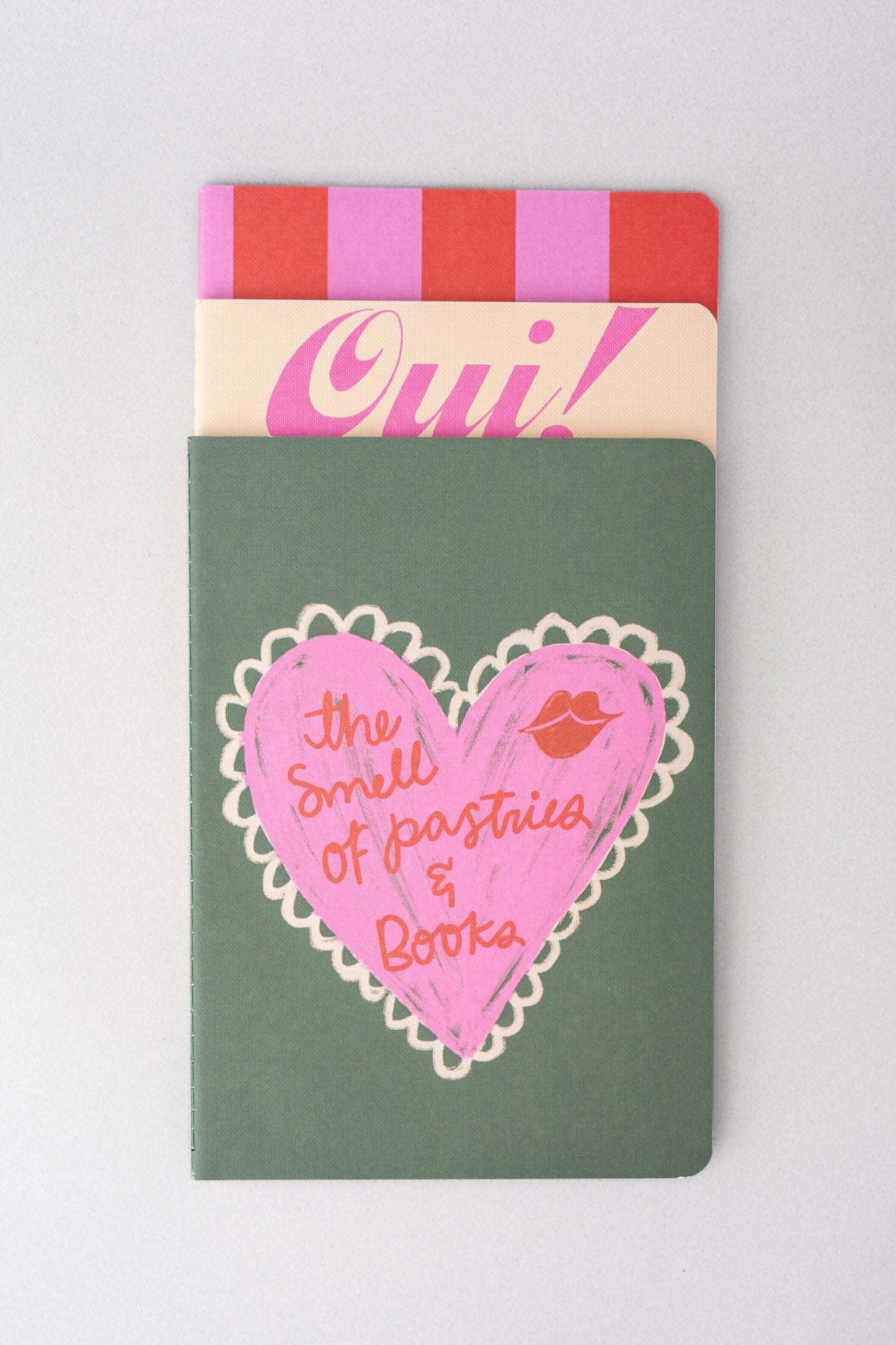 Notebook with pink heart design and text on a gray background